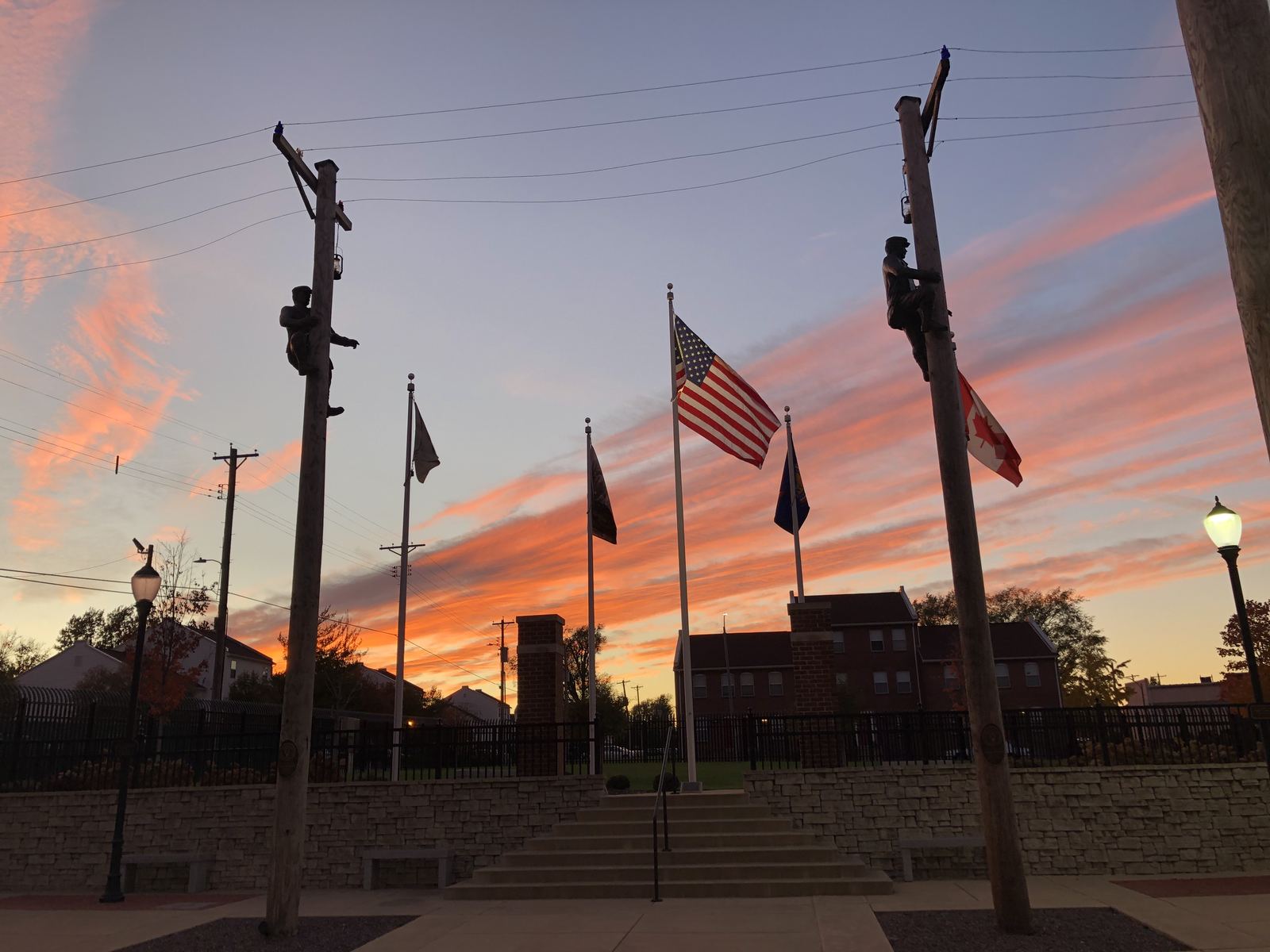 The IBEW founders' memorial plaza in St. Louis at dusk, ringed by flags